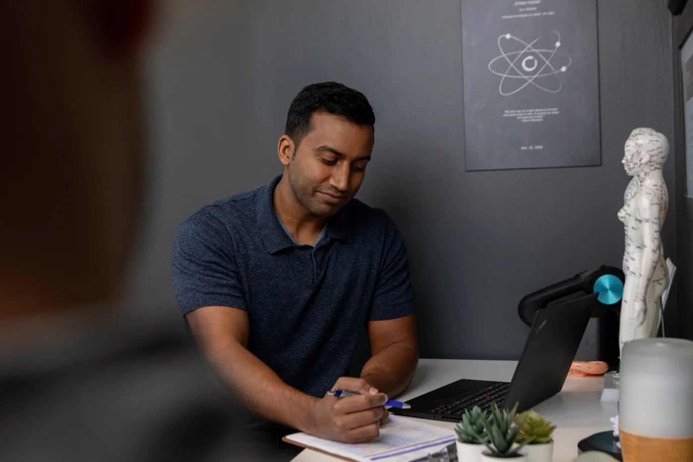 Practitioner reviewing notes on a clipboard during a nutrition consultation at iON