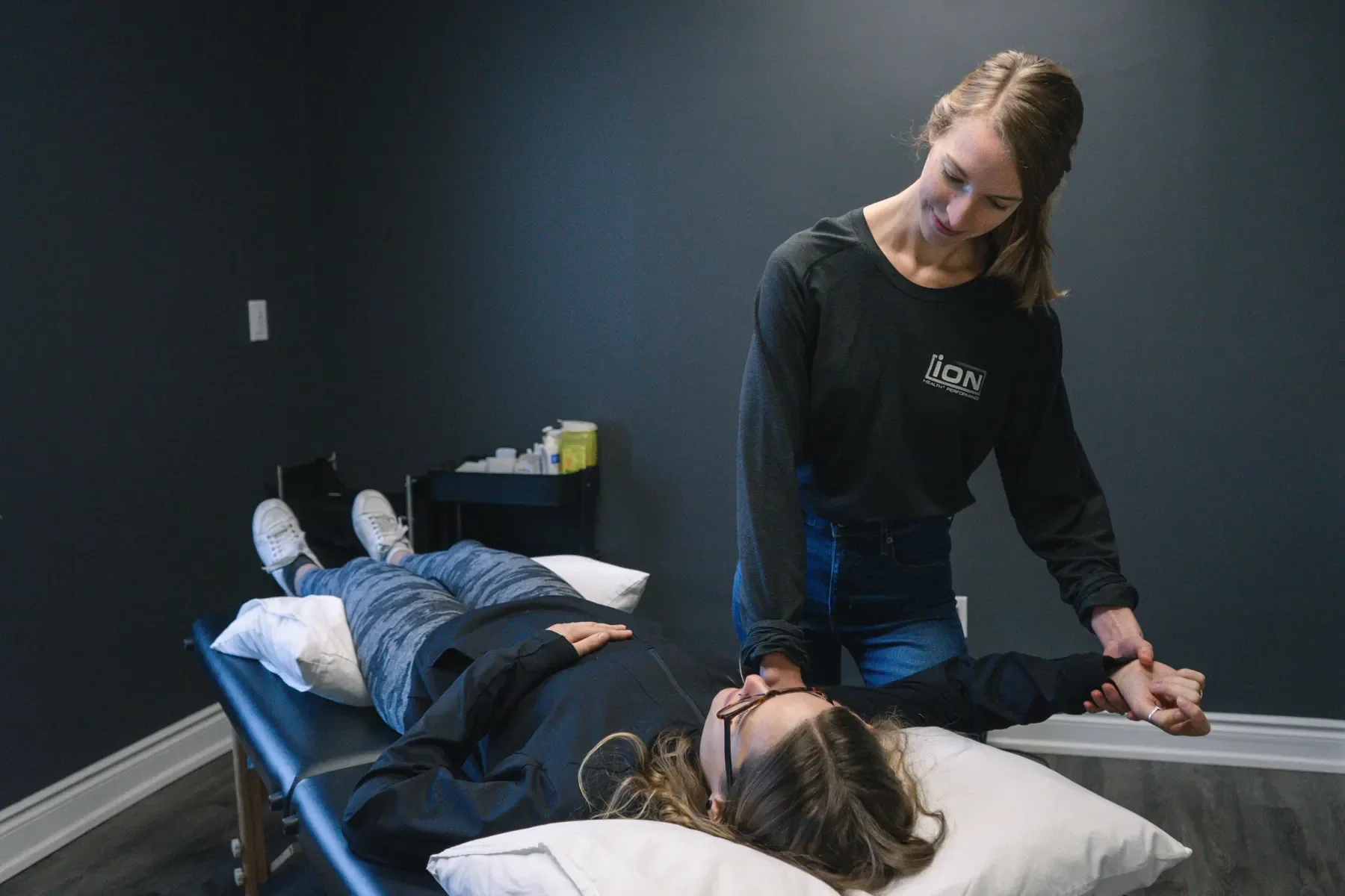Stephanie Foxman assessing and treating a client’s shoulder at iON